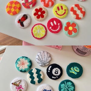 May include: A collection of colorful, round, hand-tufted coasters. Designs include smiley faces, rainbows, flowers, and geometric patterns. The coasters are made with various colors of yarn and are arranged on a white surface.