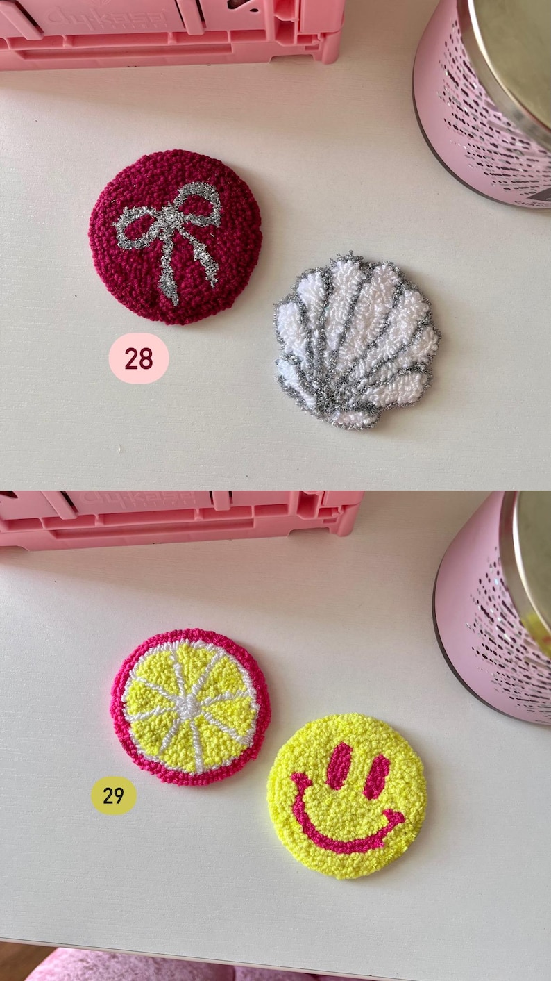 May include: A collection of colorful, circular, embroidered patches. Designs include a red circle with a silver bow, a white and silver seashell, a lemon slice, and a yellow smiley face with pink details. The number 28 and 29 are visible.