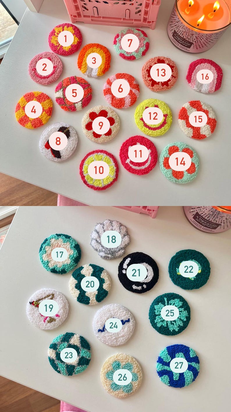 May include: A collection of 27 colorful, handmade, round coasters. Each coaster features a unique design, including floral patterns, stripes, and geometric shapes. The coasters are made with a textured, looped yarn and are arranged on a white surface.