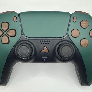 May include: A dark green and black PlayStation 5 controller with brown wooden buttons. The controller has a textured surface and a PlayStation logo on the front.