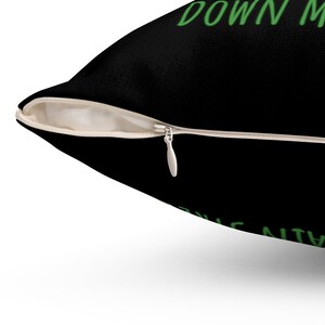 Puede incluir: Almohada negra con cierre de cremallera y texto verde que dice "Down with the patriarchy".