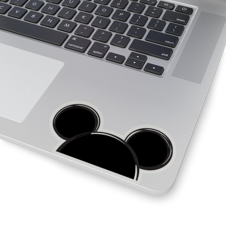 Op de afbeelding: Een zwart-witte Mickey Mouse-sticker op een zilveren laptop.