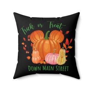 Puede incluir: Coj&iacute;n negro con un gr&aacute;fico blanco de calabazas y el texto "Trick or Treat Down Main Street".