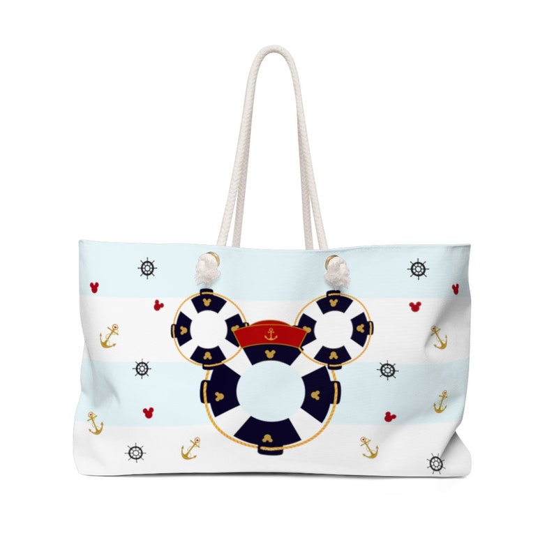 K&ouml;nnte beinhalten: Eine wei&szlig;e und blaue gestreifte Tragetasche mit einem Mickey-Mouse-Design aus Rettungsringen. Die Tasche hat wei&szlig;e Kordelgriffe und zeigt Anker, Herzen und Schiffsr&auml;der.
