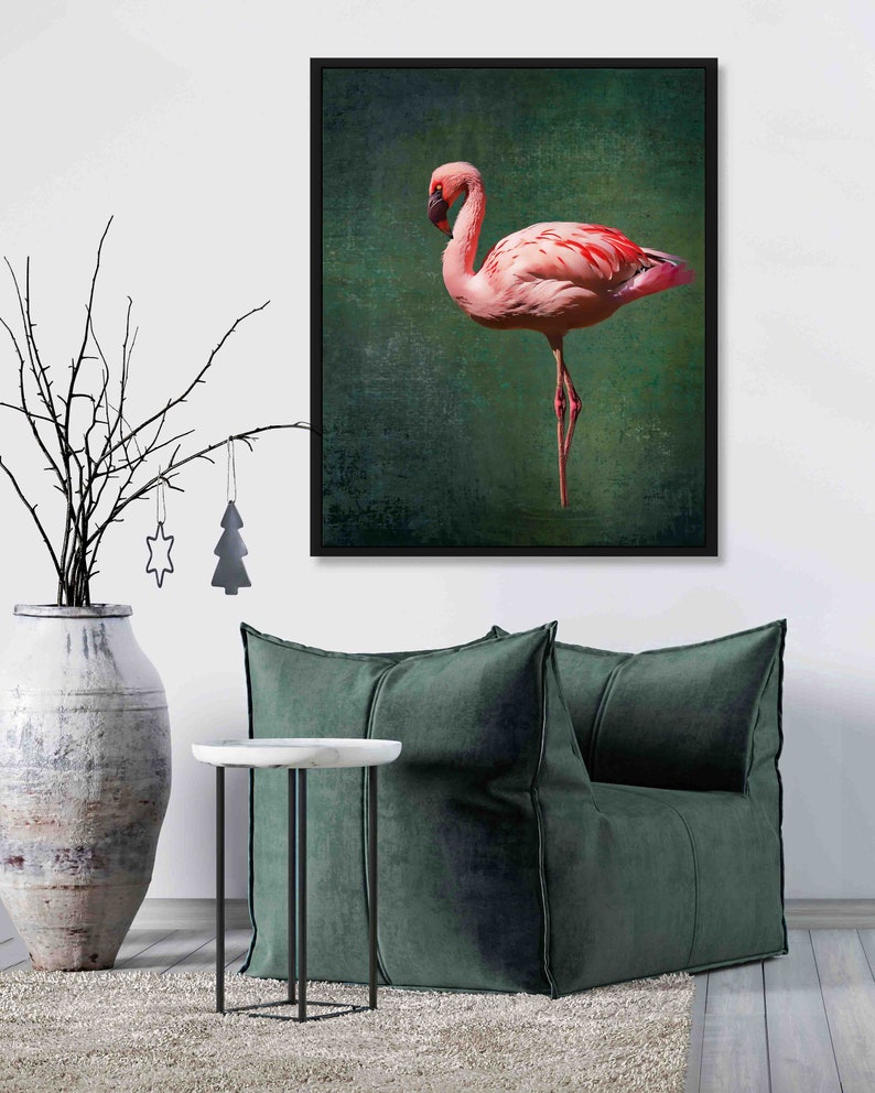 May include: A framed print of a pink flamingo standing on one leg against a green background.