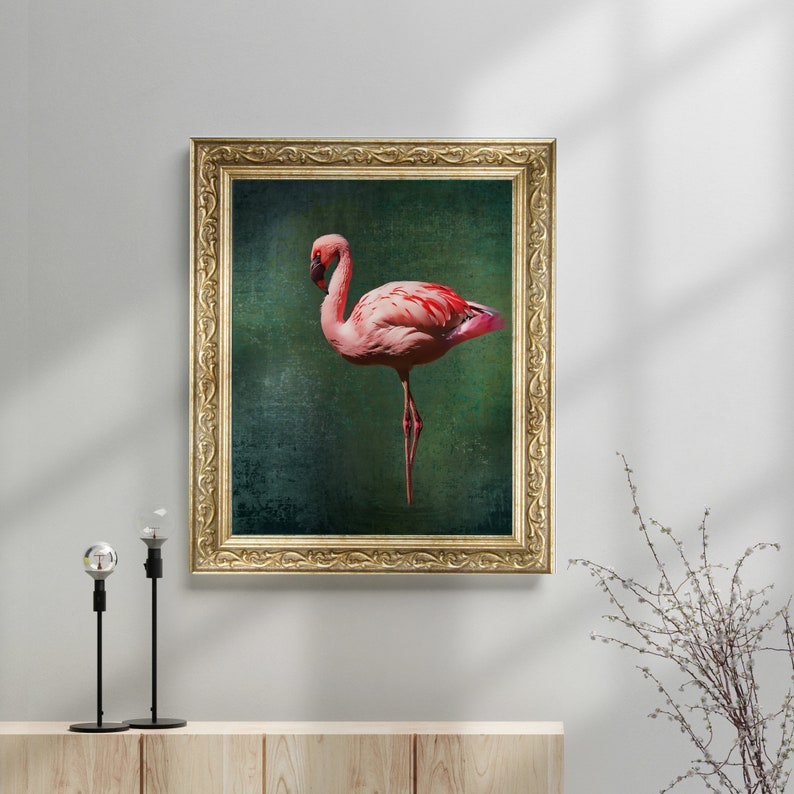 May include: A framed print of a pink flamingo standing on one leg against a dark green background.