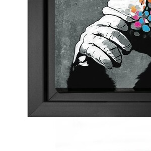 May include: A black and white print of a gorilla with a colorful spray paint design on its shoulder. The print is framed in a black frame.