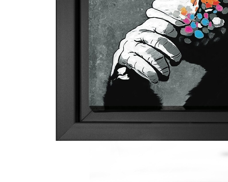 May include: A black and white print of a gorilla with a colorful spray paint design on its shoulder. The print is framed in a black frame.