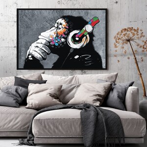 May include: A black and white illustration of a chimpanzee wearing headphones with colorful accents. The chimpanzee is looking to the side and has a thoughtful expression. The background is a gray, textured surface.