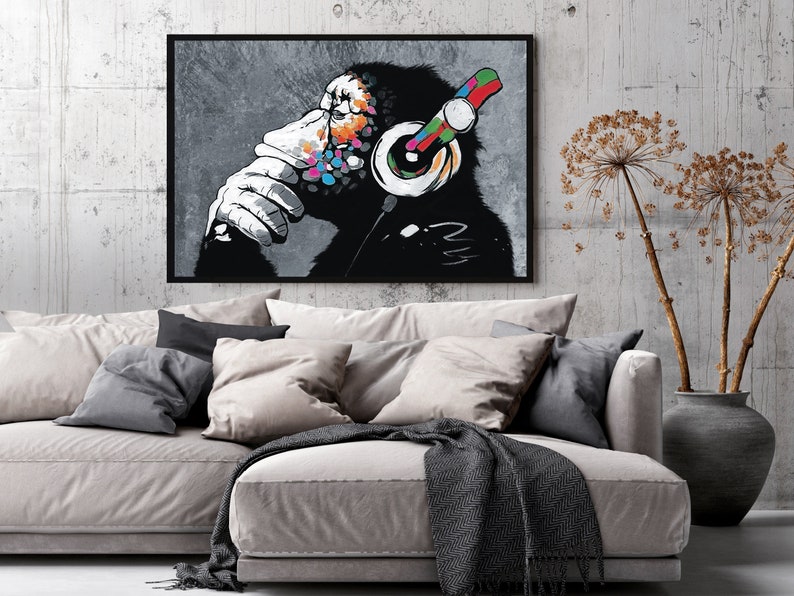 May include: A black and white illustration of a chimpanzee wearing headphones with colorful accents. The chimpanzee is looking to the side and has a thoughtful expression. The background is a gray, textured surface.
