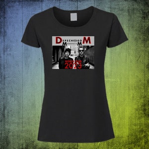 May include: Black t-shirt featuring a red and white graphic of Depeche Mode's Memento Mori World Tour 2023. The graphic shows two men in black and white, standing in an alleyway.