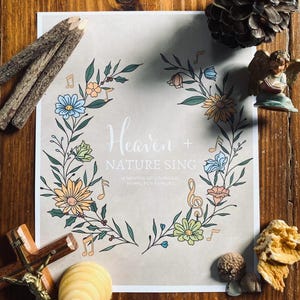 May include: A printable poster with a floral wreath design. The wreath is made of green leaves, flowers, and musical notes. The text "Heaven + Nature Sing" is in the center of the poster. The text "12 Months of Liturgical Hymns for Families" is below the wreath.