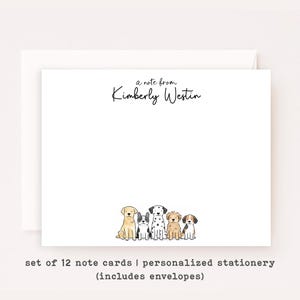 May include: White stationery set featuring a note from "Kimberly Westin" in elegant script. The bottom of the card features a row of illustrated dogs. The set includes 12 note cards and envelopes.