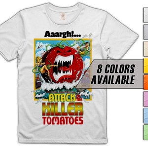 May include: White t-shirt with a graphic of a giant, red, toothy tomato with the text "Aaargh!" above it and "Attack of the Killer Tomatoes" below it. The graphic is set against a blue and white background with a small, cartoon figure of a person in the upper right corner.