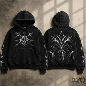 May include: Black hoodie with a distressed, vintage look. Features a white, abstract design on the front, back, and sleeves. The hoodie has a front pocket and a drawstring hood. The brand name "Crowco" is printed in a stylized font at the bottom right.