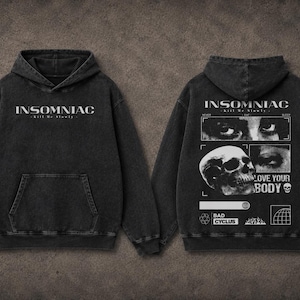 以下が含まれることがあります： 前面に白いブロック文字で「INSOMNIAC」という文字が入った黒いパーカー。背面にはスカルグラフィックと「LOVE YOUR BODY」の文字が描かれています。パーカーにはフロントポケットとフードが付いています。