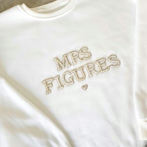 May include: A set of three ceramic mugs with a speckled, matte finish. The mugs are in shades of cream, light gray, and dark gray. Each mug has a simple, minimalist design, perfect for coffee or tea.