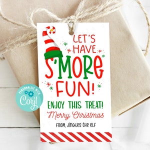 May include: A white gift tag with red and green stripes at the bottom. The tag features a cartoon elf hat with a candy cane and the text "Let's *Have* S'more Fun!"  "Enjoy this treat! Merry Christmas" and "From, Jingle the Elf" are also included on the tag.