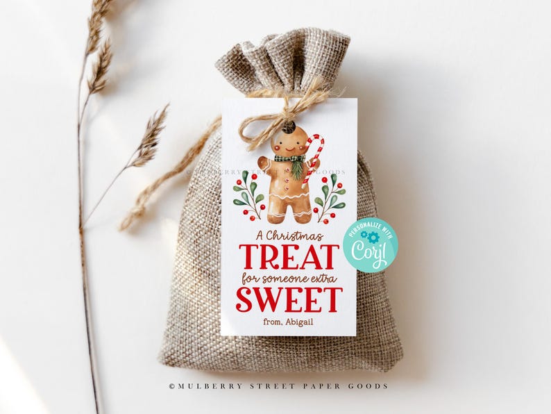 May include: A white gift tag with a gingerbread man illustration and the text "A Christmas Treat for someone extra SWEET from. Abigail". The tag is tied with twine and is sitting on a burlap bag.