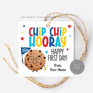 May include: A square gift tag with a cartoon cookie character wearing glasses and holding a pencil and a flag that says "Back 2 School". The tag has the words "Chip Chip Hooray Happy First Day!" in colorful letters.