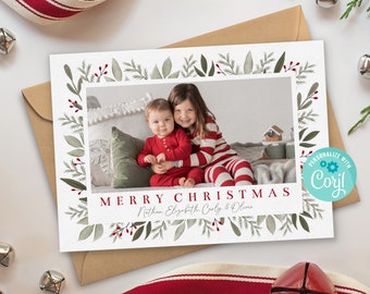 May include: A Christmas card with a green and red floral border. The card features a photo of two children in red and white pajamas. The text "Merry Christmas" is printed in red with the names "Nathan, Elizabeth, Carly & Oliver" printed below.