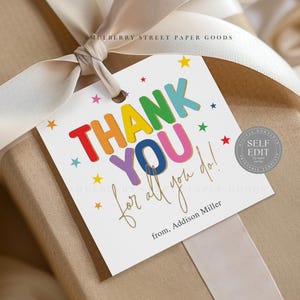 May include: A gift tag with the words "THANK YOU" in colorful block letters, accented with stars. The tag is tied to a wrapped gift with a cream-colored ribbon. The text "for all you do!" and "from, Addison Miller" are also on the tag.
