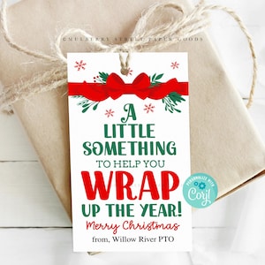 Puede incluir: Una etiqueta de regalo de Navidad roja y verde con un lazo rojo y el texto "¡Un pequeño algo para ayudarte a envolver el año! Feliz Navidad de Willow River PTO".