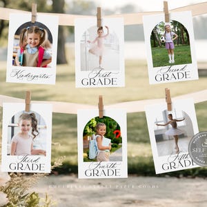 May include: A series of six white cards with photos of children, each labeled with a grade level from Kindergarten to Fifth Grade. The cards are clipped to a ribbon with wooden clothespins, with a blurred outdoor background.