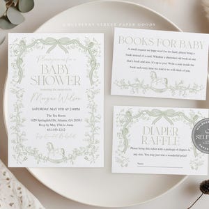 May include: A baby shower invitation suite with a soft green floral design. The invitation, a book request card, and a diaper raffle card are displayed on a white plate. The invitation includes the text "Baby Shower" and event details.