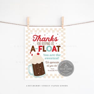 Op de afbeelding: Een bedrukte kaart met een retro soda shop thema. De kaart bevat de woorden "Thanks for keeping us A-FLOAT" in rode en bruine tekst, samen met een cartoon soda float. De kaart hangt aan een waslijn.