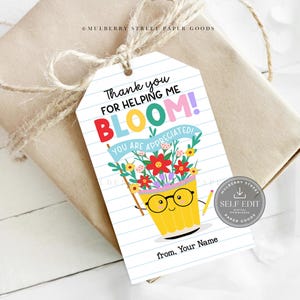May include: A gift tag with the text "Thank you for helping me bloom! You are appreciated!" features a cartoon pencil pot with flowers, glasses, and pencils. The tag is attached to a wrapped gift with twine.