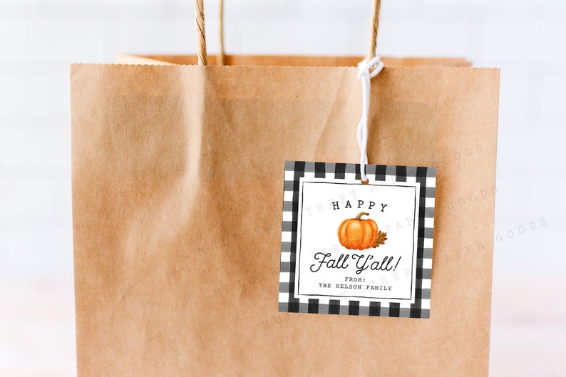 Op de afbeelding: Een zwart-wit geblokt cadeau-etiket met een pompoenillustratie en de tekst "Happy Fall Y'all! From: The Nelson Family".