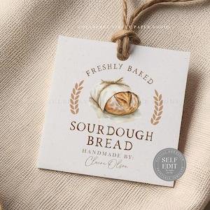 May include: A square tag with a watercolor illustration of a sourdough loaf wrapped in cloth. The tag reads "Freshly Baked Sourdough Bread Handmade by Claire Olson." Wheat stalks frame the top and bottom of the bread illustration. A Self Edit seal is in the bottom right corner.