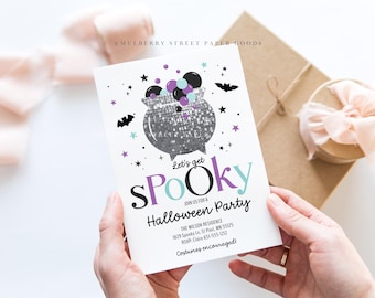 May include: A white card with a purple and blue "Let's get Spooky" Halloween party invitation. The card features a silver cauldron with purple and blue bubbles and bats. The text includes the party details, including the address, RSVP information, and the phrase "Costumes encouraged".
