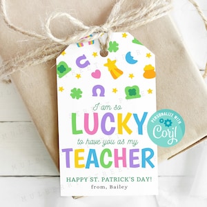 May include: A white gift tag with a colorful shamrock, rainbow, and horseshoe design. The text reads "I am so LUCKY to have you as my TEACHER. HAPPY ST. PATRICK'S DAY! from, Bailey". A blue circle with the text "PERSONALIZE WITH Cory!" is in the upper right corner.