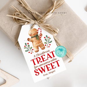 May include: A white gift tag with a gingerbread man illustration and red text that reads "A Christmas Treat for someone extra Sweet from. Abigail".