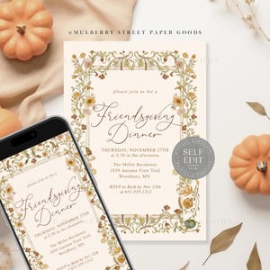 May include: An invitation for a Friendsgiving Dinner, displayed on a smartphone and a printed card, with floral border and text. The invitation is surrounded by small pumpkins and dried leaves, creating a fall theme.