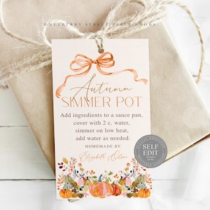 May include: A gift tag with the text "Autumn Simmer Pot" and instructions. The tag features a watercolor bow and autumn-themed illustrations of pumpkins and foliage. The tag is tied to a wrapped gift with twine.
