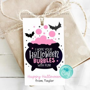 May include: A white gift tag with a black cauldron filled with pink bubbles and bats flying around it. The text reads "I hope your Halloween Bubbles with Fun!" and "Happy Halloween from, Taylor".