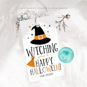 Op de afbeelding: Een wit cadeau-etiket met een zwarte heksenhoed, een oranje bezem en de tekst "Witching you a Happy Halloween!" met een blauwe cirkel met de tekst "Personaliseer met Cory!"
