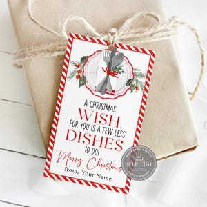 May include: A Christmas gift tag with a red and white striped border. The tag features a plate, fork, and spoon graphic with the text "A Christmas Wish For You Is A Few Less Dishes To Do!" and "Merry Christmas".