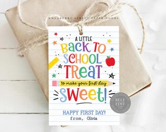 以下が含まれることがあります： 「A Little Back to School Treat」の文字と学校をテーマにしたイラストが描かれた、カラフルなギフトタグ。タグは、ひもで包まれたギフトに付けられています。