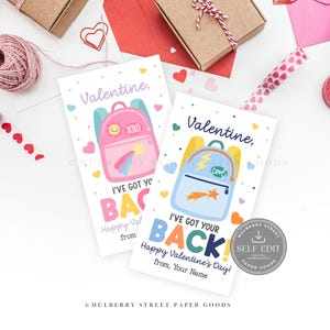 May include: Two Valentine's Day cards with backpack illustrations. One pink backpack has a rainbow and the text "XOXO". The other is blue with a lightning bolt and the word "Cool". The cards read "I've got your back" and "Happy Valentine's Day!"