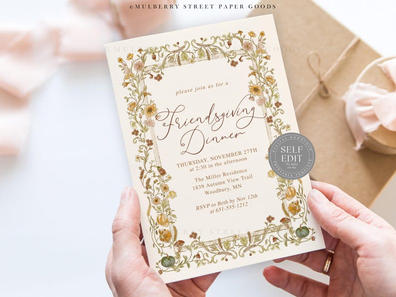 May include: An invitation for a Friendsgiving Dinner, featuring floral and botanical illustrations. The text reads "Friendsgiving Dinner" and includes the date, time, and location. The invitation is held in hands.