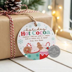 May include: A round Christmas gift tag with the words "holiday Hot Cocoa". The tag has illustrations of hot chocolate mugs, gingerbread men, and candy canes. The tag is attached to a wrapped gift with a red and white string.
