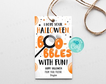 May include: A rectangular white gift tag with orange and black text reading I HOPE YOUR HALLOWEEN BOO-BBLES WITH FUN! HAPPY HALLOWEEN FROM YOUR FRIEND. Brayden. It features a bubble wand graphic, orange circles, and a brown twine string.