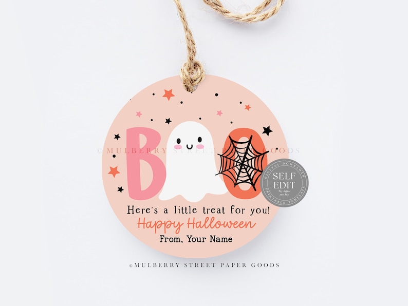 May include: A round, peach-colored Halloween gift tag with the word "BOO" in pink and orange, a white ghost, and a black spiderweb. The tag includes the text "Here's a little treat for you! Happy Halloween".