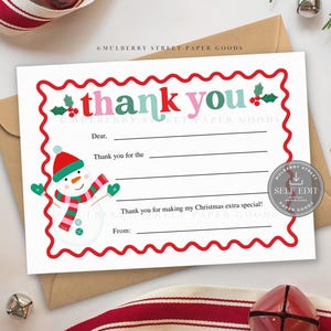 May include: A white fill-in-the-blank thank you card with a red scalloped border and a snowman illustration. The words "thank you" are in pink and teal. The card is on a brown envelope.