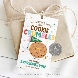 Puede incluir: Una etiqueta de regalo con el texto "No matter how the cookie crumbles, we truly appreciate you!" presenta una galleta de dibujos animados con gafas. La etiqueta está atada a un regalo envuelto con hilo.