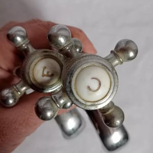 May include: Two antique chrome faucet handles with white porcelain knobs. The knobs have the letters 'C' and 'F' printed on them.